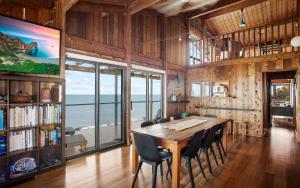 a dining room with a large wooden table and chairs at Cliffs End Beach Shack 105 Gold Coast Drive in Carrickalinga
