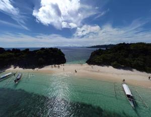 an aerial view of a beach with two boats in the water at Airusxander Front Beach Resort in Caramoan