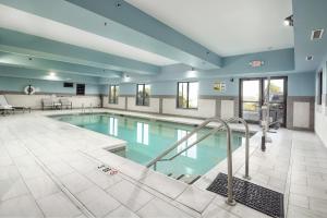 Une grande piscine avec des escaliers se trouve dans un bâtiment. dans l'établissement Holiday Inn Express Hotel & Suites Festus-South St. Louis, an IHG Hotel, à Festus