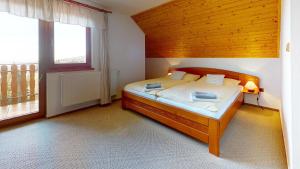 a bedroom with a bed and a large window at Penzion Patrik Mikulčin vrch in Vápenice