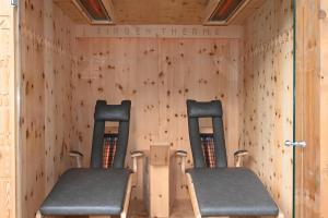 two chairs in a room with wooden walls at Residence Martha in Biberwier