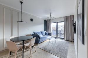 - un salon avec un canapé bleu et une table dans l'établissement Apartament blisko Starego Miasta z widokiem na Motławę, à Gdańsk