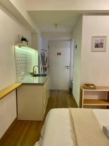Zimmer mit einem Bett und einer Küche mit einer Theke in der Unterkunft Camaya at tanglin apartement in Lontar