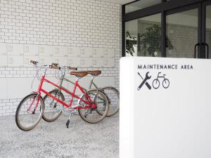 dos bicicletas estacionadas frente a un edificio en Hotel Gee Haive, en Mishima