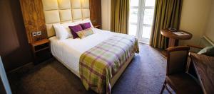 une chambre d'hôtel avec un lit et une fenêtre dans l'établissement The Gilvenbank Hotel, à Glenrothes