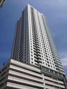 a tall white building with a blue sky at 2 Bedrooms - Thamrin Executive Apartment at Jakarta Center in Jakarta