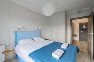 um quarto com uma cama azul com duas almofadas em Apartament blisko Starego Miasta z widokiem na Motławę em Gdańsk
