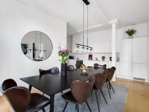 ein Esszimmer mit einem schwarzen Tisch und braunen Stühlen in der Unterkunft Sanders Leaves - Pleasant Four-Bedroom Apartment In Downtown Copenhagen in Kopenhagen