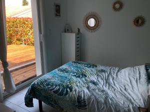 um quarto com uma cama ao lado de uma porta de vidro deslizante em Villa avec Jacuzzi em Saint-Martin-de-Londres