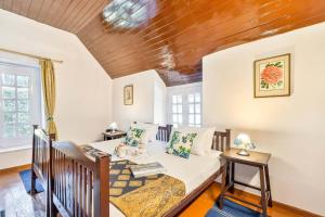a bedroom with a bed and a wooden ceiling at StayVista at 8Oaks in Dalhousie