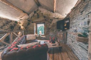 Romantic Getaway - Sauna and Jacuzzi - El Clandestino في ستاومونت: غرفة معيشة مع أريكة جلدية وجدار حجري