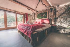 1 dormitorio con 1 cama grande en una pared de piedra en Romantic Getaway - Sauna and Jacuzzi - El Clandestino, en Stoumont