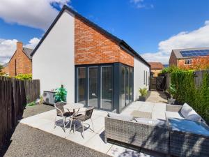 a garden with a patio with a table and chairs at Contemporary 2 bedroom eco home with a twist in Marton