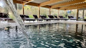 a pool with chairs and a water fountain at Hotel-Restaurant Liebnitzmühle in Raabs an der Thaya