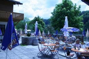 un groupe de tables et de chaises avec parasols dans l'établissement Fischerstüberl, à Gaishofen