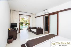 sypialnia z łóżkiem, telewizorem i kanapą w obiekcie Villa Diana Bali 16 Bedrooms w mieście Seminyak