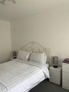 a bedroom with a white bed with two night stands at Teith court apartment with private parking. in Stirling
