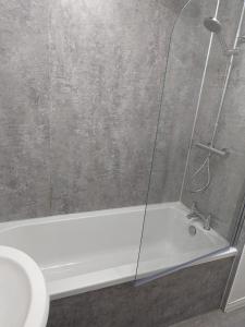 a bathroom with a shower with a white bath tub at Teith court apartment with private parking. in Stirling
