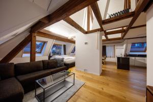 a living room with a couch and a bed at Welcome Apartments Spiez in Spiez