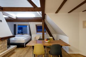 a room with a table and chairs and a bed at Welcome Apartments Spiez in Spiez