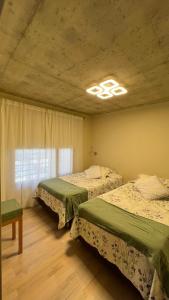 1 dormitorio con 2 camas y ventana en ALIWEN Rauli en San Martín de los Andes