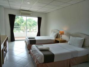 Postel nebo postele na pokoji v ubytování โรงแรมเวลลิงตัน