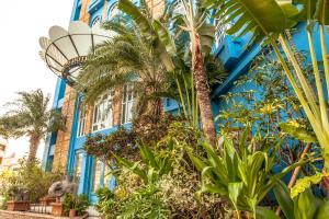 un bâtiment bleu avec des palmiers devant lui dans l'établissement Anna King Hotel, à Chiayi