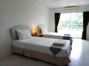 Postel nebo postele na pokoji v ubytování โรงแรมเวลลิงตัน