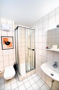 a bathroom with a shower and a toilet and a sink at Hôtel de Ville d'Ollon in Ollon