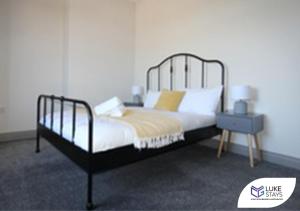 a bedroom with a black and white bed and a nightstand at Luke Stays - Alum Waters in New Brancepeth