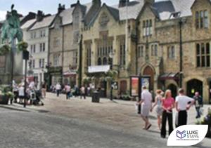 a group of people walking down a city street with buildings at Luke Stays - Alum Waters in New Brancepeth