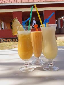 trois verres de boissons assis sur une table dans l'établissement The Sparrow Hotels, à Soroti