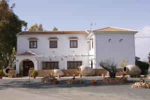 a white house with a lot of plants in front of it at Rural La Paloma in Villanueva de Tapia