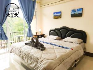 a bedroom with a large bed with a large window at เกสต์เฮาส์ชูบีมา Guesthouse Chubeema Coffee & Tea in Ban Mai Ngae