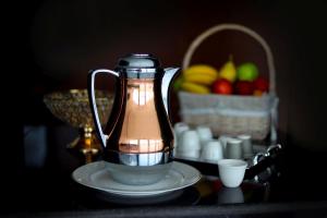 um liquidificador sentado numa mesa com um cesto de fruta em Golden Crown Hotel Alseeb Muscat em Seeb