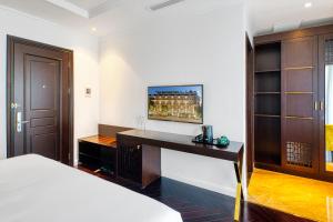 Schlafzimmer mit einem Schreibtisch und einem TV an der Wand in der Unterkunft The Almin Hotel in Hạ Long