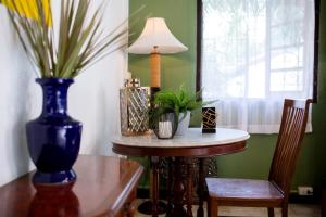 a table with a blue vase and a lamp on it at Natural Park Resort Pattaya in Jomtien Beach