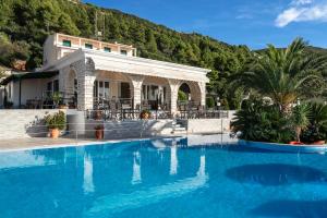 a large swimming pool in front of a house at Sunset Premium Studio C in Agios Nikitas