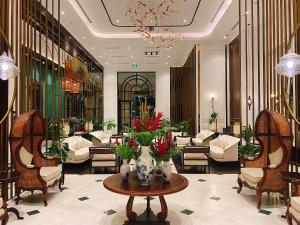 a lobby with chairs and a table with flowers on it at Potique Hotel in Nha Trang