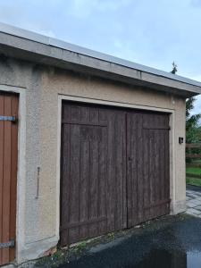 een garage met een grote houten garagedeur bij Ferienwohnung Carola in Altenburg