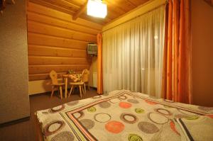 a bedroom with a bed and a table with chairs at Willa Marysieńka in Zakopane