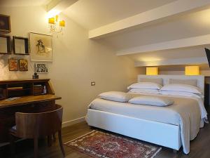 a bedroom with a white bed and a desk and a table at B&B Balsimelli12 in San Marino