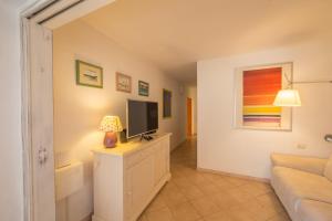 a living room with a television and a couch at Casa degli Stecchi in Capoliveri