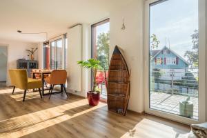 a room with a surfboard and a dining room at Seekind in Kressbronn am Bodensee