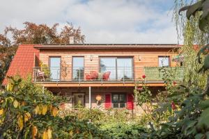 a house with a balcony with red chairs on it at Seekind in Kressbronn am Bodensee