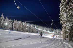 a person is skiing down a snow covered ski slope at Bungalows Rogla in Zreče