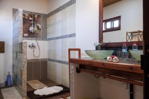a bathroom with two sinks and a shower at Hotel Ambalakely in Ambalakely