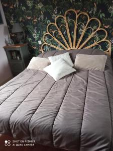 a bedroom with a bed with a gold headboard at LA PETITE MEUNIERE in Tramain