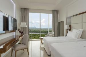 a hotel room with two beds and a large window at Pyramid Continental Hotel in Juba