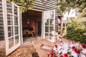 um pátio com uma mesa de madeira e janelas amplas em CRASH'NSTAY - The Silo Bungalow em Sprang-Capelle